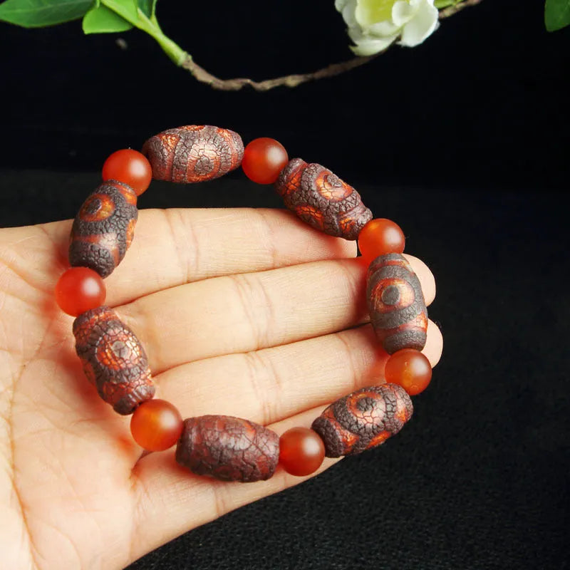 Distressed agate Tibet bead bracelet with three-eye motifs and multiple traditional bead styles on wrist