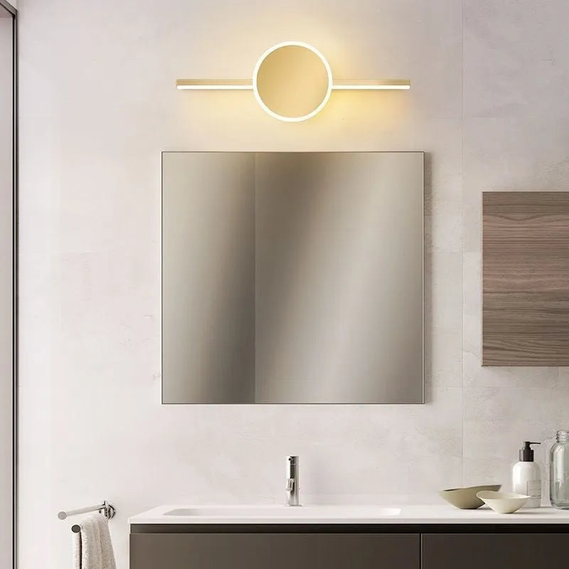 Gold-framed LED mirror cabinet with integrated makeup lights mounted on a bathroom wall.