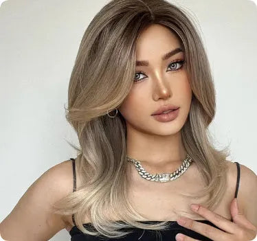 Mid-length curly synthetic wig with gradient colour and long bangs on a wig stand.