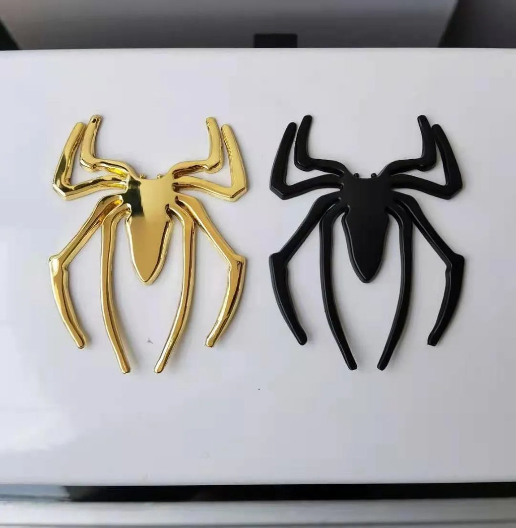 Three-dimensional metal spider car bumper sticker in zinc alloy, shown in gold colour.