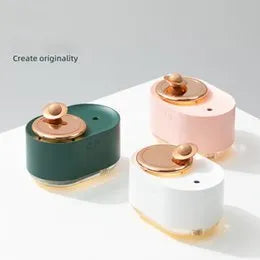 Green rotating planet-shaped humidifier with night light on a wooden table next to a USB cable.