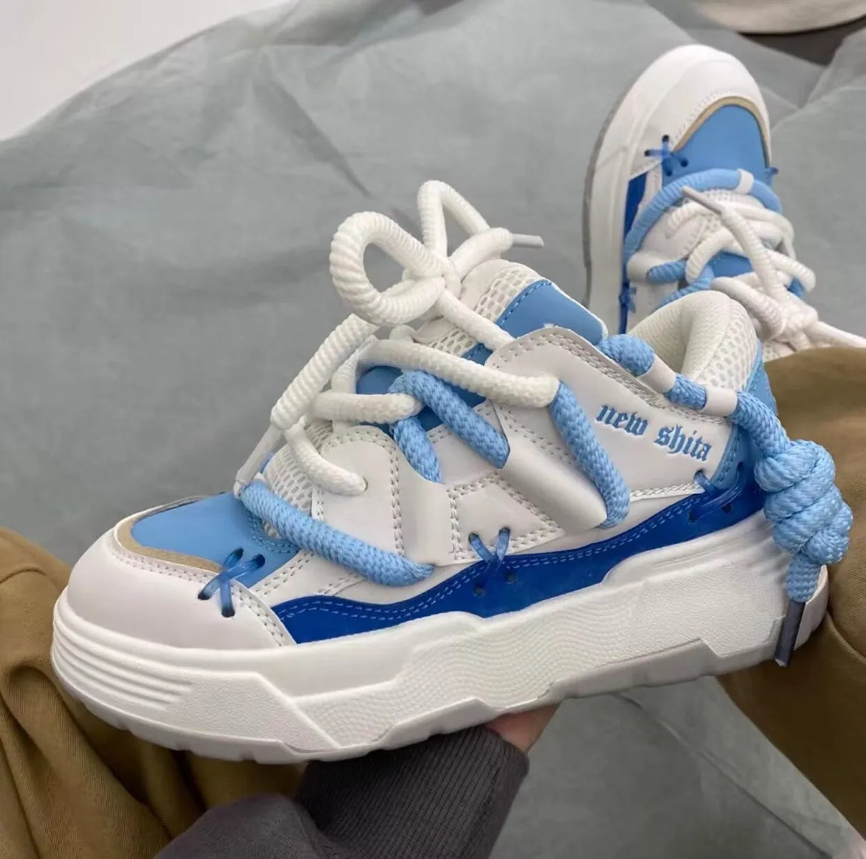 Women's grey retro clunky sneakers with a thick rubber sole and front lace-up closure on a white background.