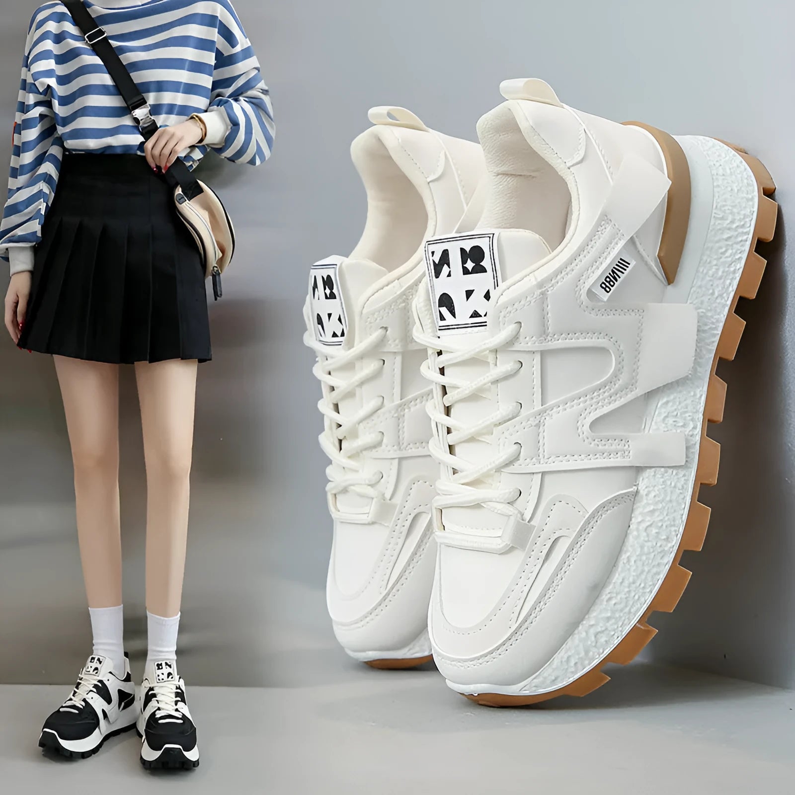 A pair of solid-colour low-top sneakers with a round toe and front lace-up, shown in white or black.
