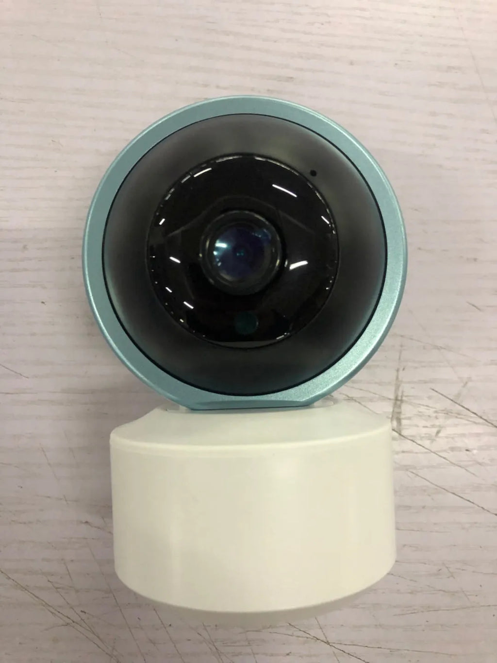 White indoor security camera with 360-degree rotation on stand showing WiFi connectivity