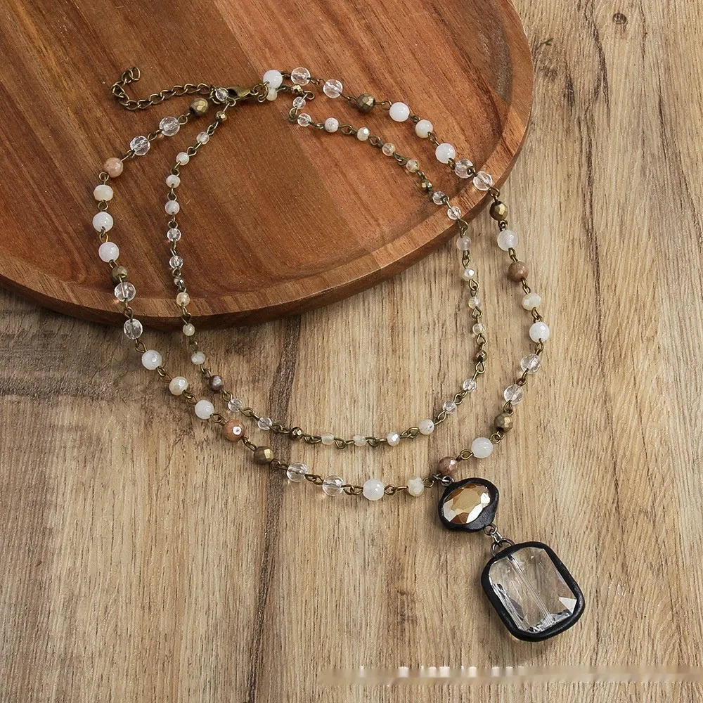 Tribal style necklace with two-layer pendant featuring natural stone and glass elements on chain
