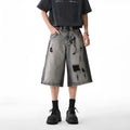 Grey high street washed cotton denim shorts with a loose, cropped fit on a hanger.
