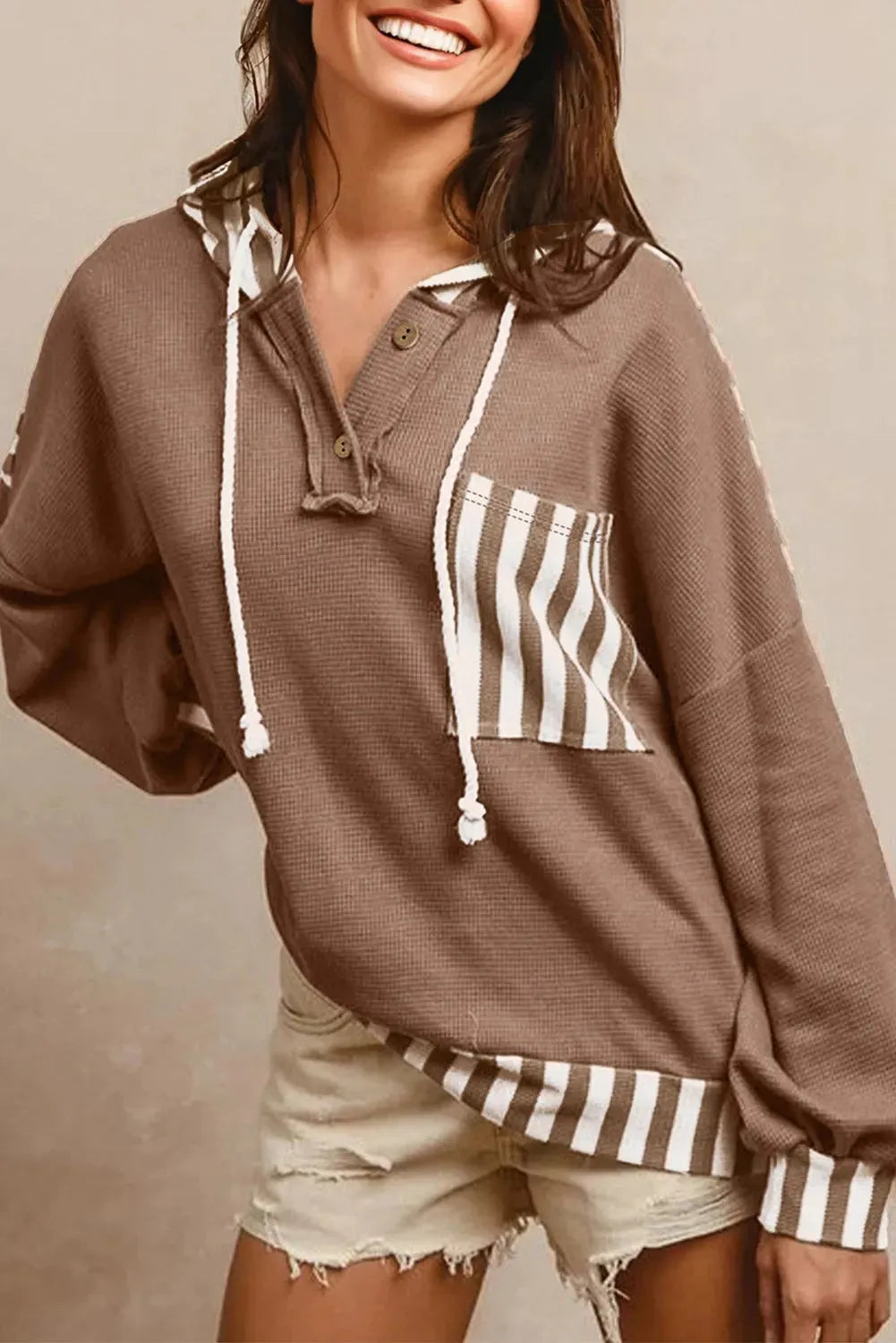 Straw yellow waffle texture hoodie with striped patchwork panels and a button neck.