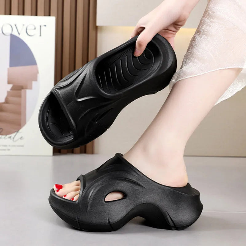 Women's white thick-soled EVA beach slippers with round toe, shown on a sandy background.