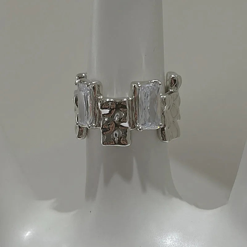 Geometric cross zircon ring with silver plating and open gemstone setting showing three-dimensional decoration