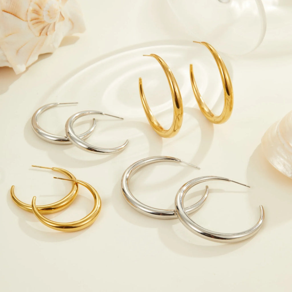 Titanium steel hoop earrings in gold and steel finishes, available in large and small sizes with simple geometric design