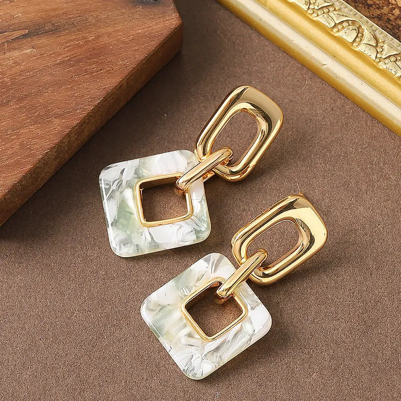 A pair of hollow geometric square earrings with chamfered corners, made from electroplated copper.