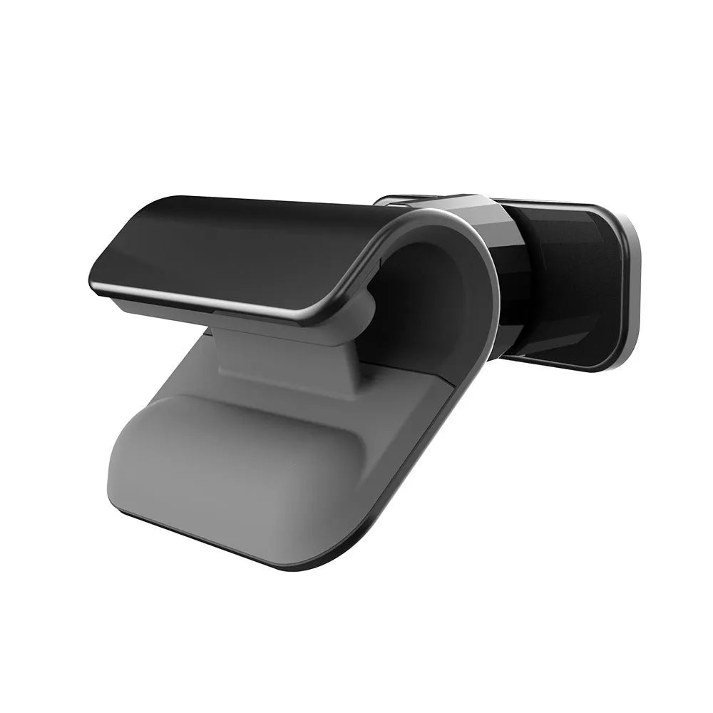 Black 360-degree rotating gravity car phone holder mounted on a car dashboard, holding a mobile phone.