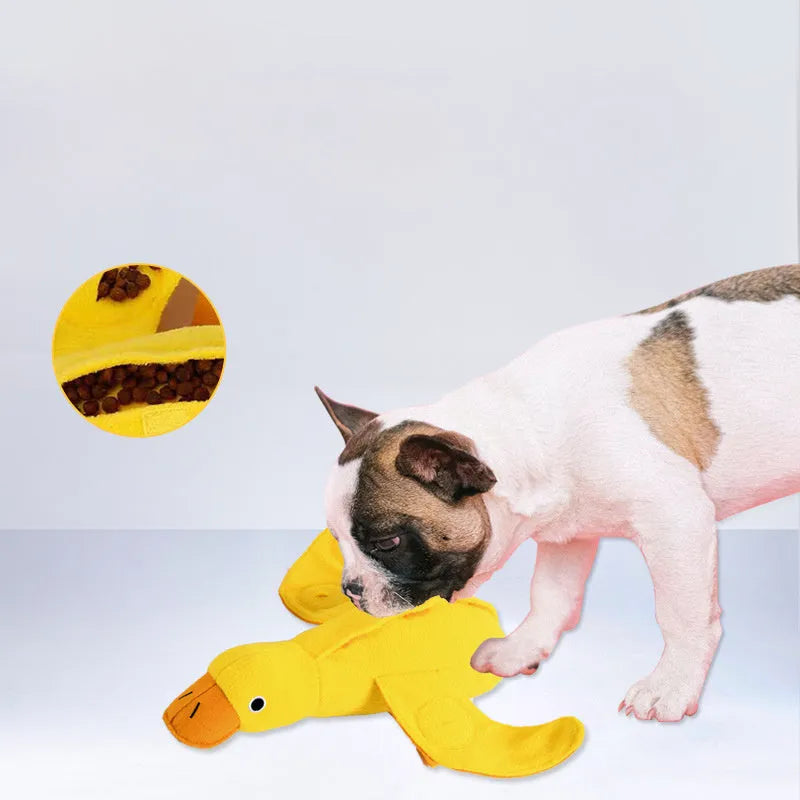 Yellow plush dog toy with attached rubber duck and a treat slot on a white background.