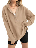 Women's loose-fitting solid colour pullover sweater with long raglan sleeves on a hanger.