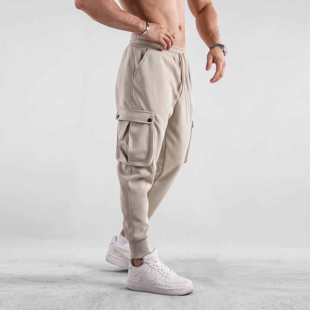 Men's loose cotton trousers with ankle ties in apricot colour showing multi-pocket design