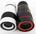 12X magnification black phone telescope lens with mounting clip extended next to a smartphone.