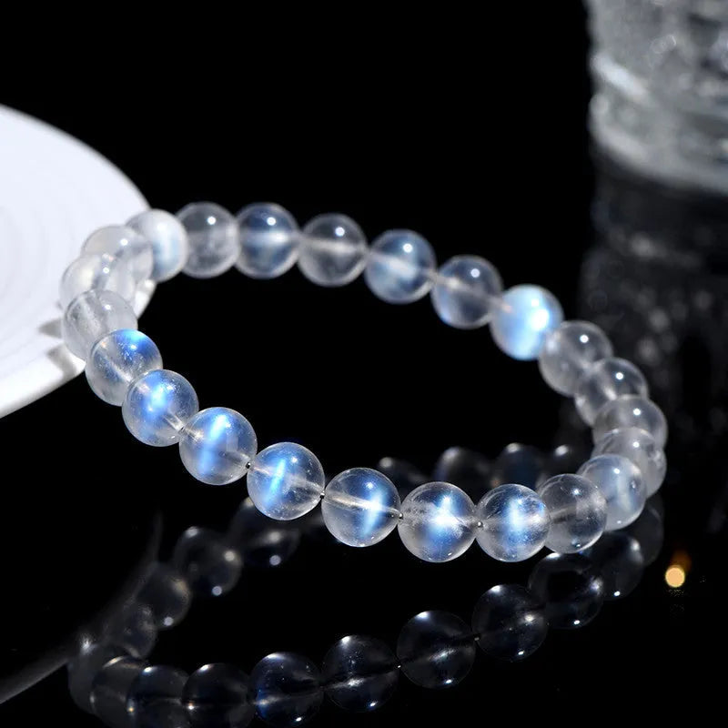 Natural blue moonlight cream body crystal bracelet on a wrist, showing polished beads.