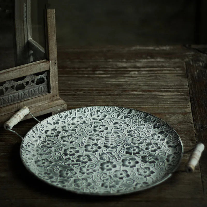 Round wrought iron storage tray in two sizes on a wooden table.