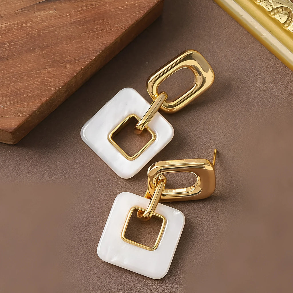 A pair of hollow geometric square earrings with chamfered corners, made from electroplated copper.