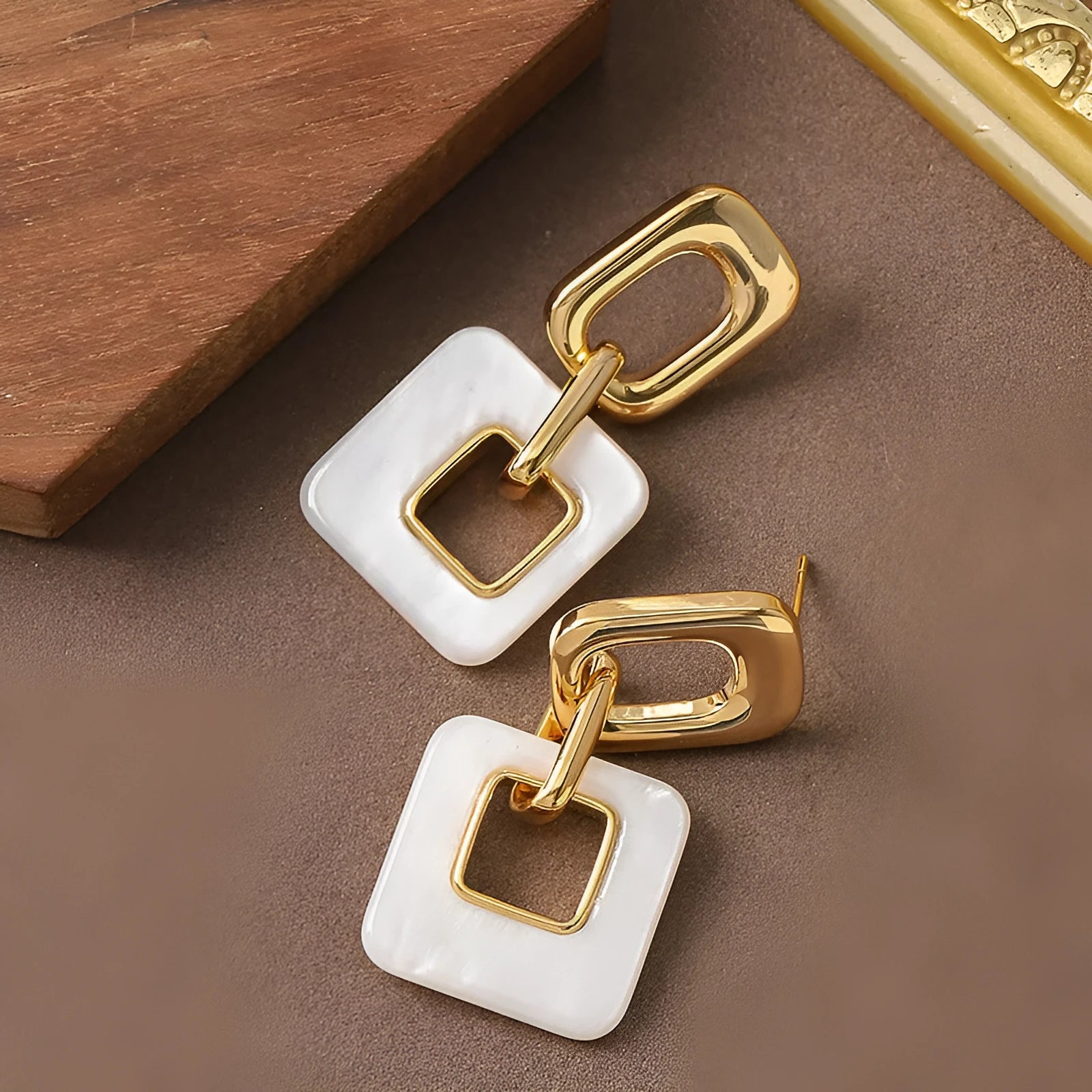 A pair of hollow geometric square earrings with chamfered corners, made from electroplated copper.