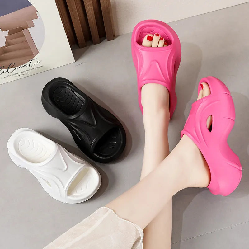 Women's white thick-soled EVA beach slippers with round toe, shown on a sandy background.