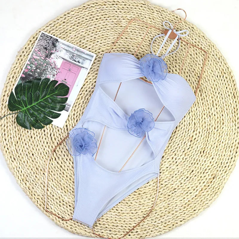 Women's black and blue striped one-piece swimsuit with a 3D flower design.