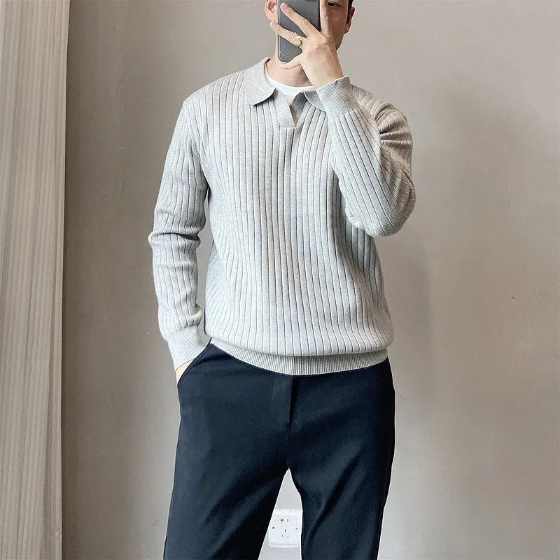 Man wearing a loose fit, textured grey knitted sweater with long sleeves for casual autumn wear.