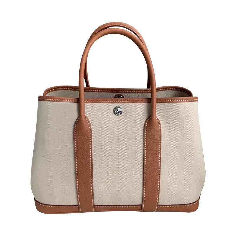 Women's canvas and genuine leather bucket tote bag with crossbody strap shown in black, brown, grey, or red.