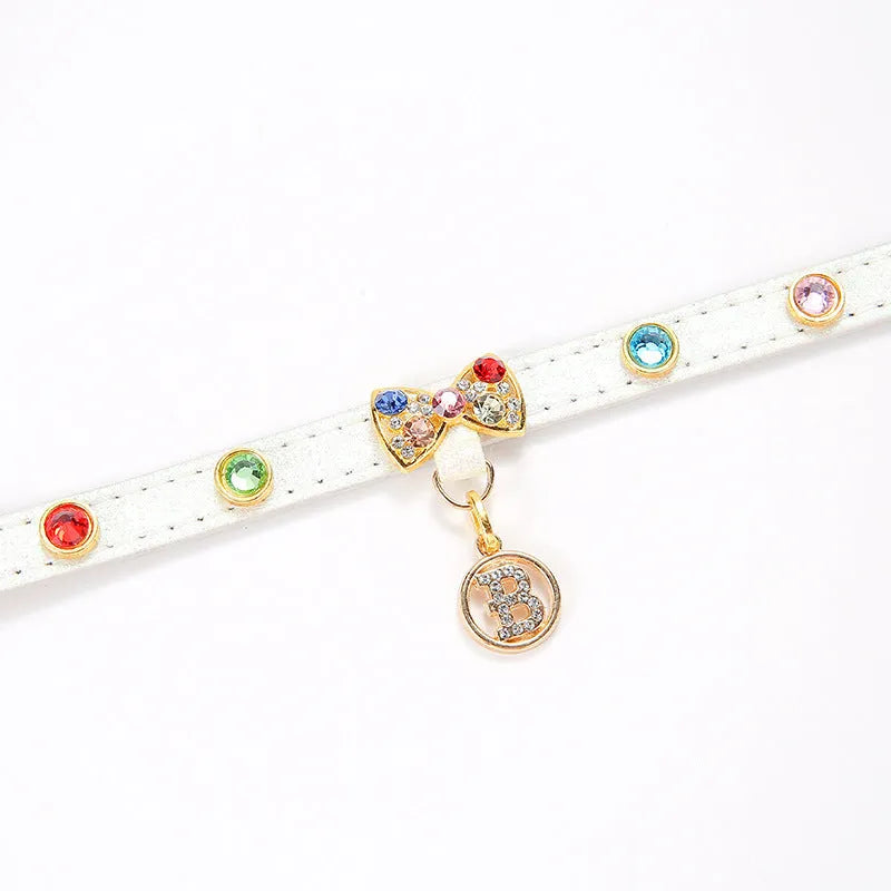 White PU leather cat collar with diamond alloy bow displayed on a surface, showing buckle and adjustable length