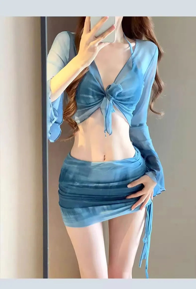 Women's blue four-piece bikini swimsuit set showing high-waisted briefs and coordinating shirt and skirt components