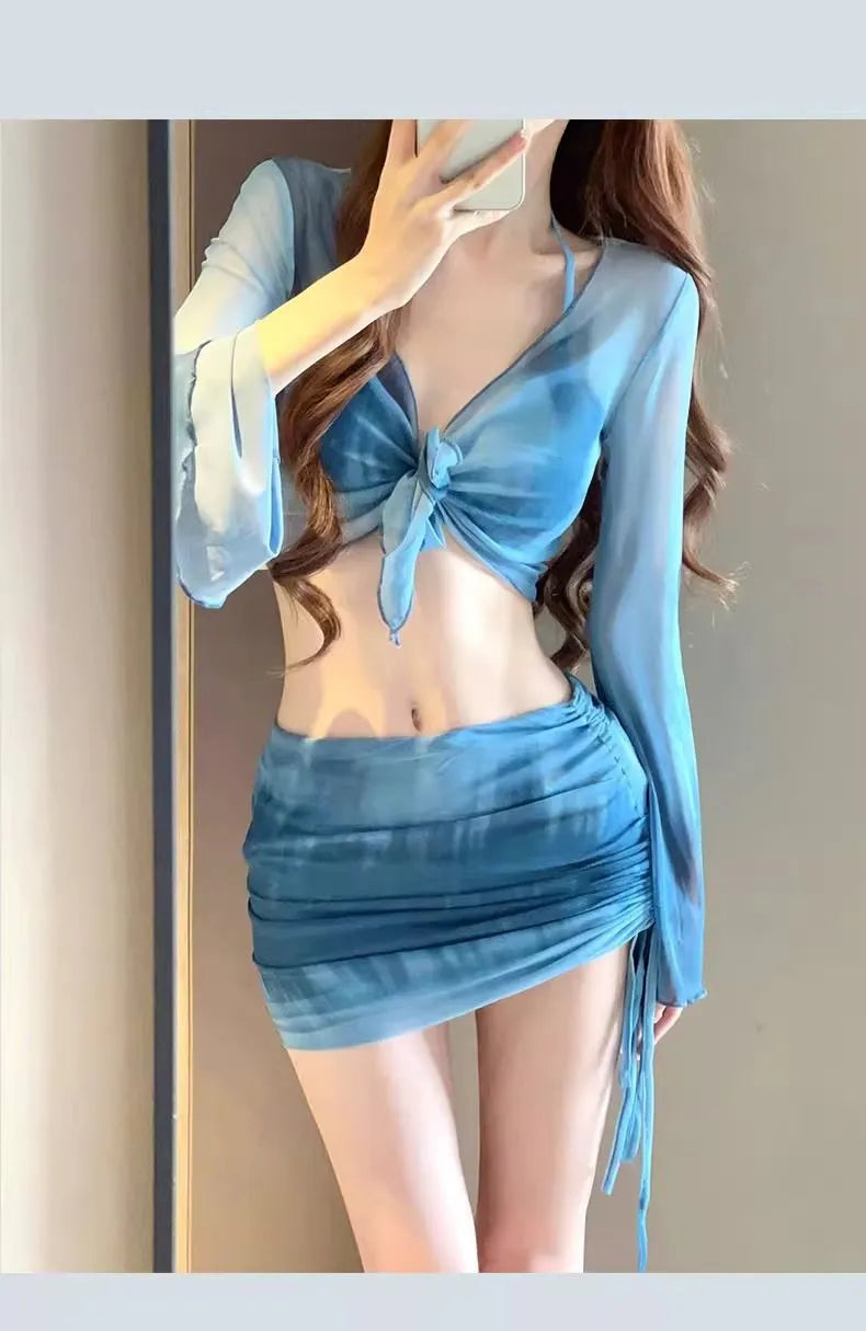 Women's blue four-piece bikini swimsuit set showing high-waisted briefs and coordinating shirt and skirt components