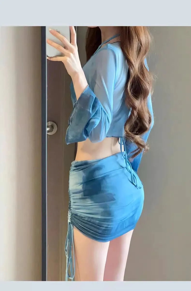 Women's blue four-piece bikini swimsuit set showing high-waisted briefs and coordinating shirt and skirt components