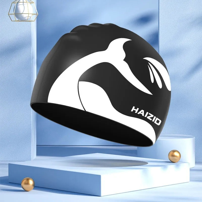 Silicone swimming cap with whale tail pattern and built-in ear protectors.