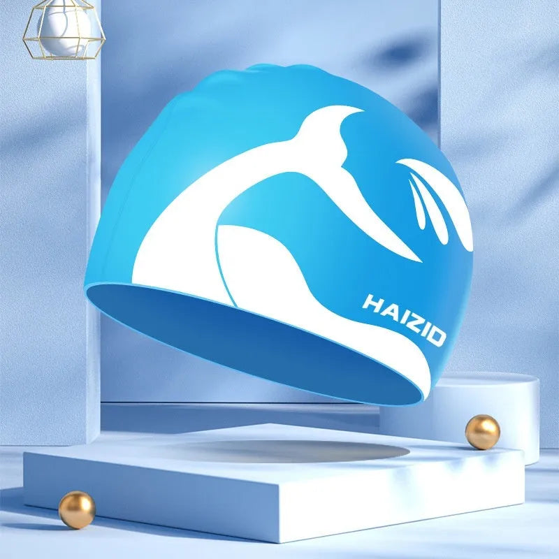 Silicone swimming cap with whale tail pattern and built-in ear protectors.
