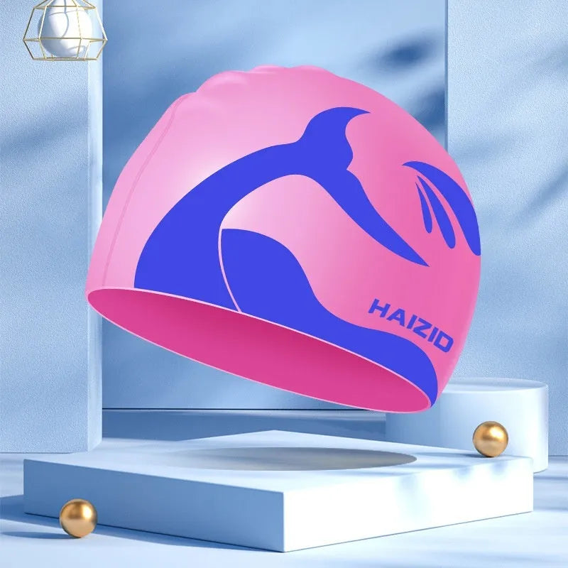 Silicone swimming cap with whale tail pattern and built-in ear protectors.