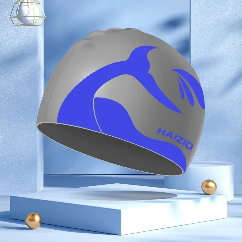Silicone swimming cap with whale tail pattern and built-in ear protectors.