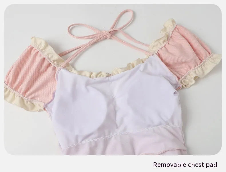 Pink women's Siamese-style one-piece swimsuit on a white background