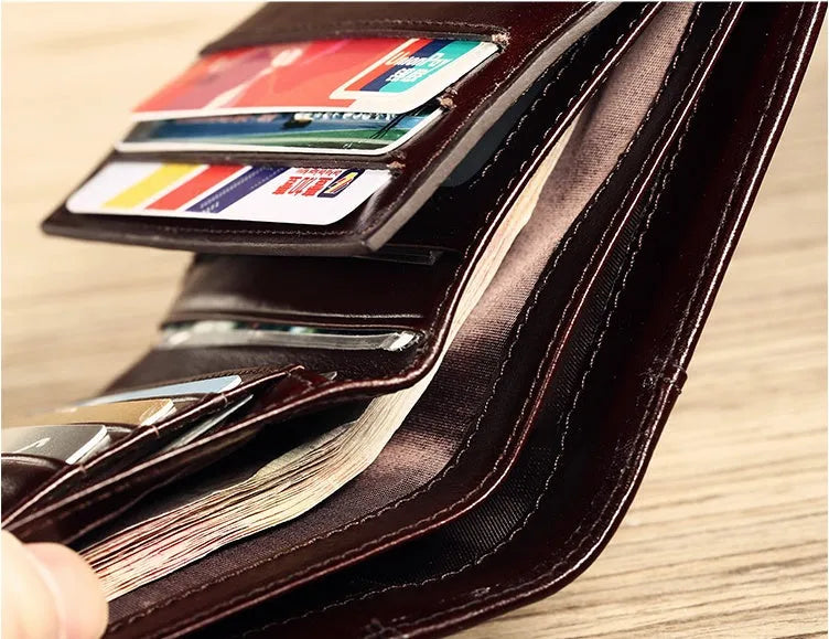 Men's black leather wallet open showing internal card slots, note compartment, and change section.