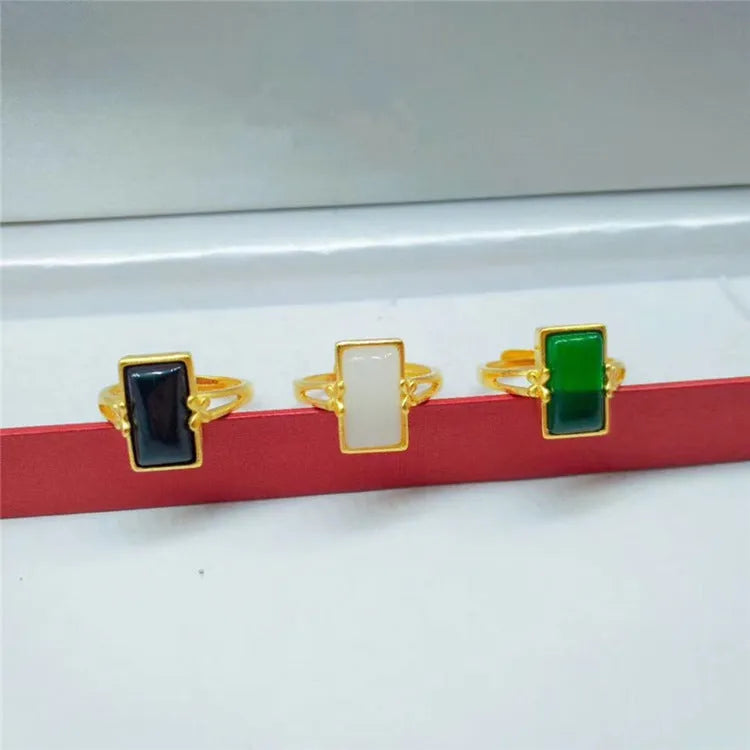 Adjustable gold-plated brass ring with a central gemstone inlay on a model's finger.