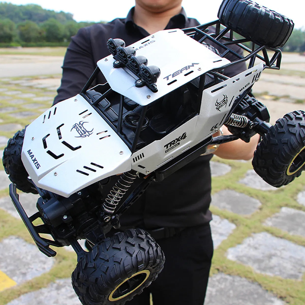 Large black 4WD remote control climbing car on rough terrain with wireless controller