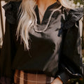 Black V-neck blouse with contrast stitching on ruffle long sleeves