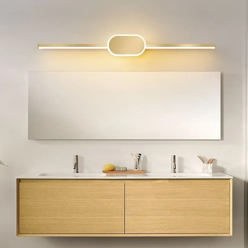 Gold-framed LED mirror cabinet with integrated makeup lights mounted on a bathroom wall.
