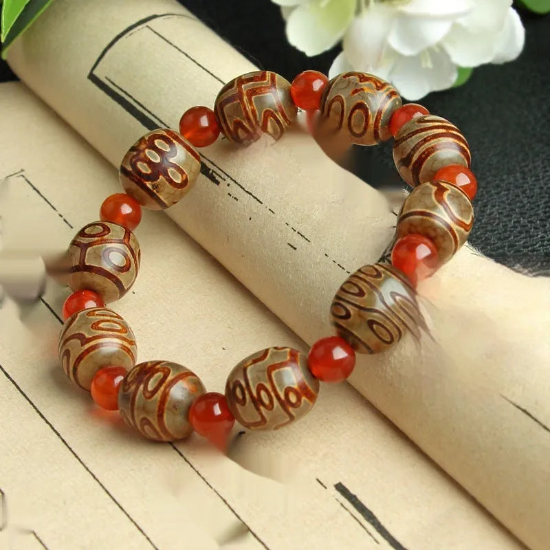 Distressed agate Tibet bead bracelet with three-eye motifs and multiple traditional bead styles on wrist