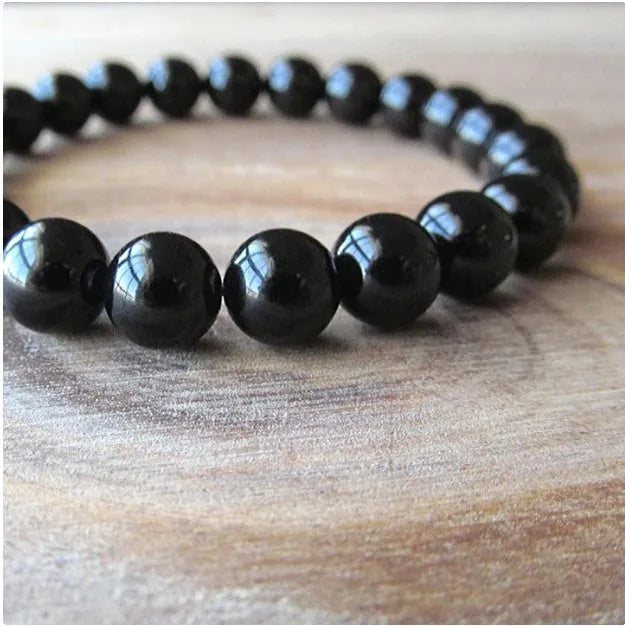 A geometric black agate bead stretch bracelet with 8mm stones on an elastic cord.