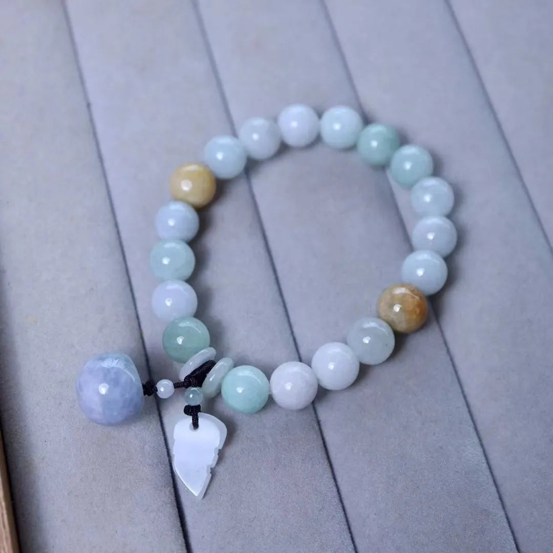 Natural green jade bracelet with Maitreya Buddha charm pendant on a wrist.