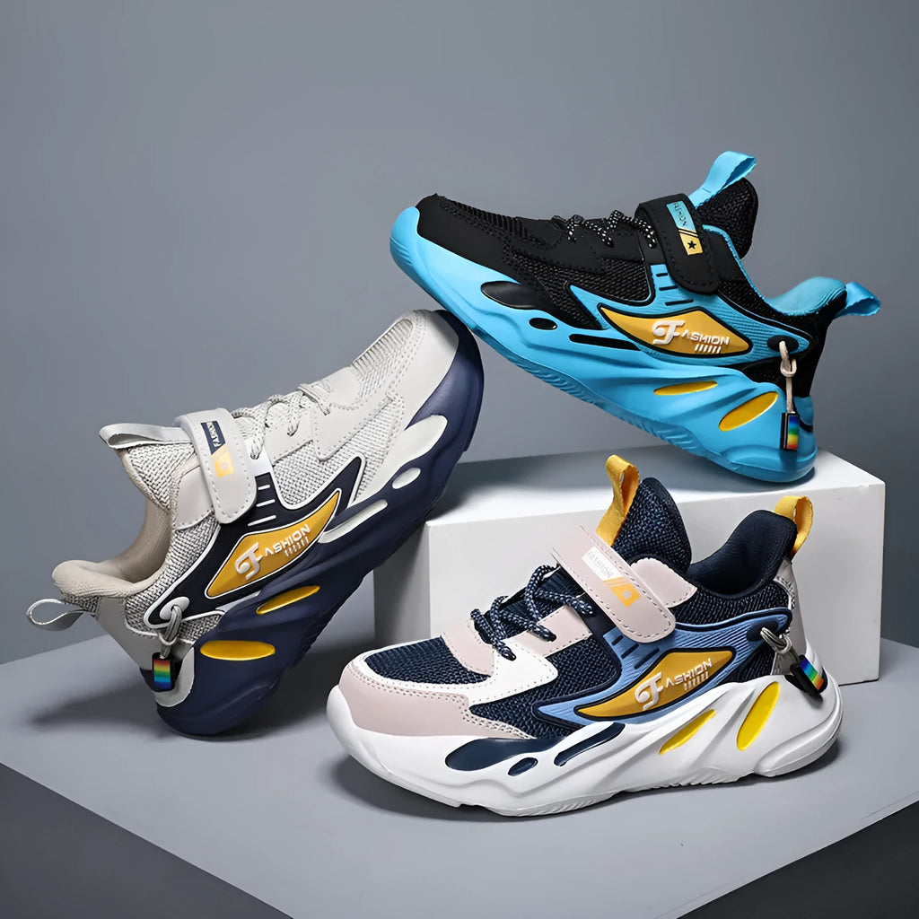 Boys' blue and black platform sports running shoes with Velcro strap on a hard ground surface.