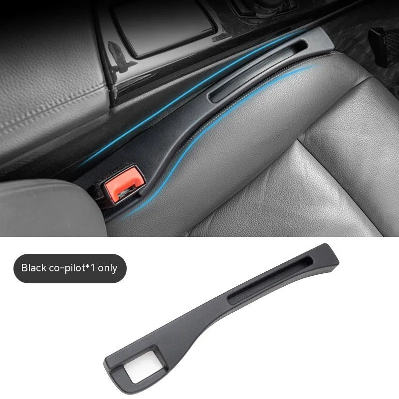 Black plastic car seat gap storage box with handle positioned between vehicle seats