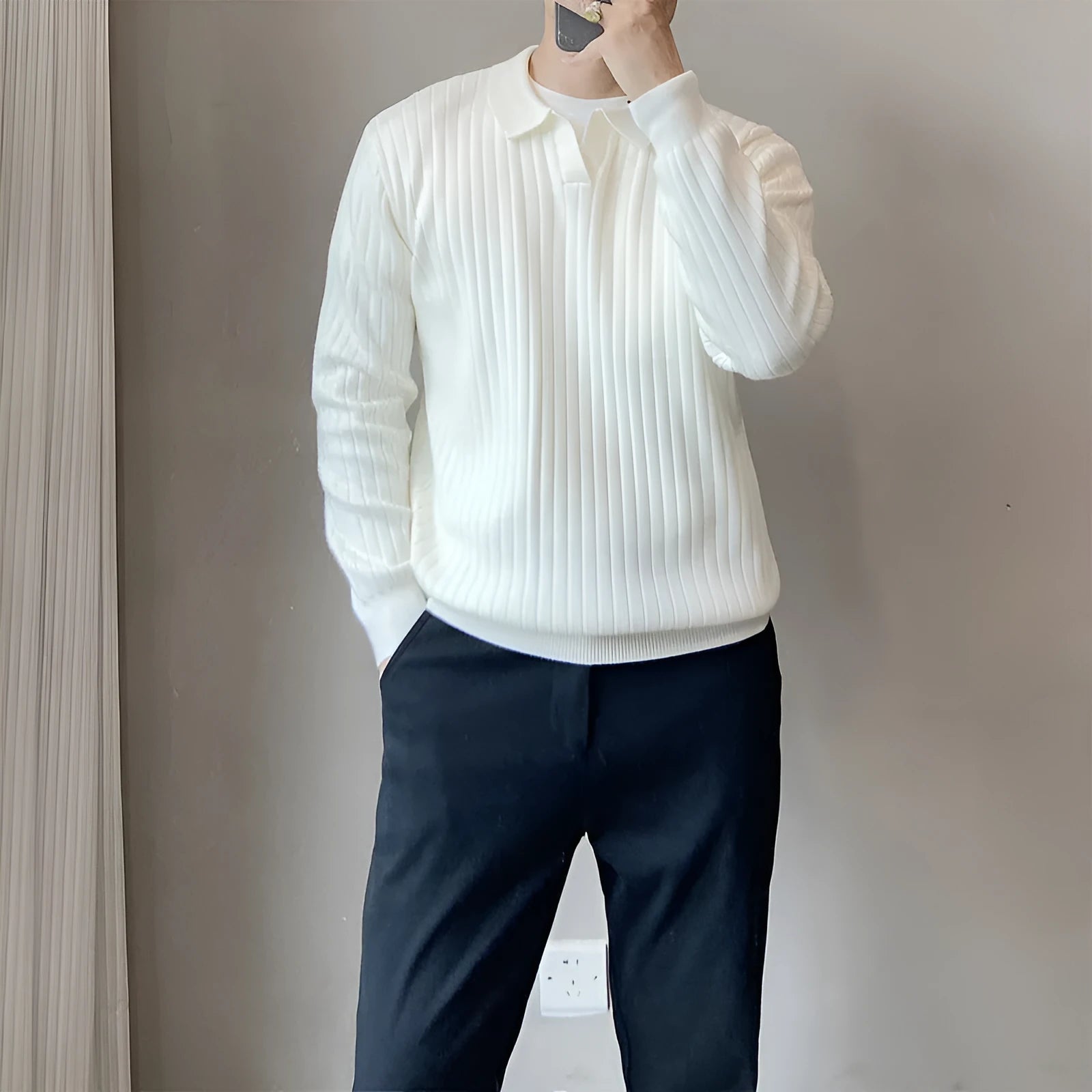 Man wearing a loose fit, textured grey knitted sweater with long sleeves for casual autumn wear.