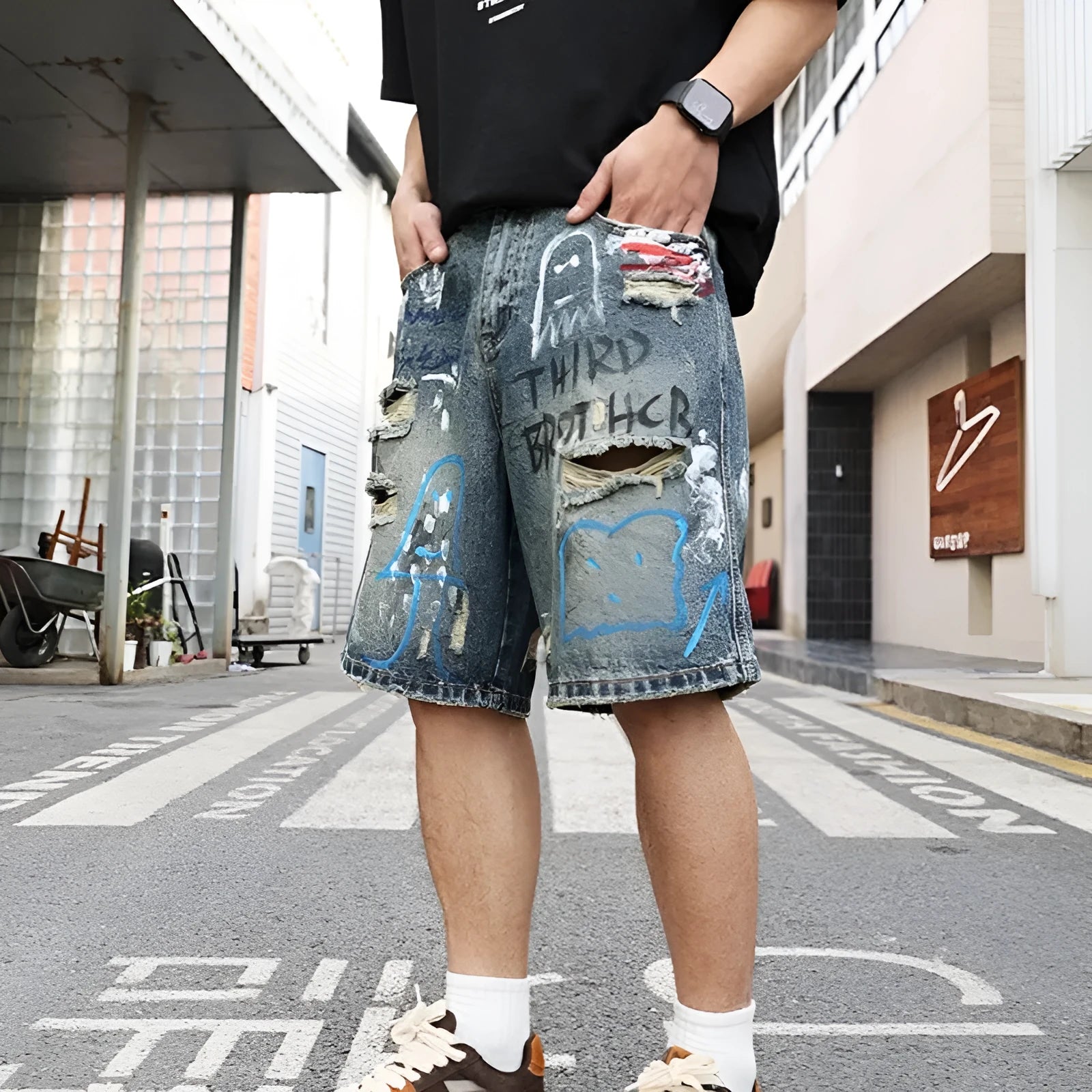 Blue men's ripped denim shorts with graffiti details and a straight leg opening.