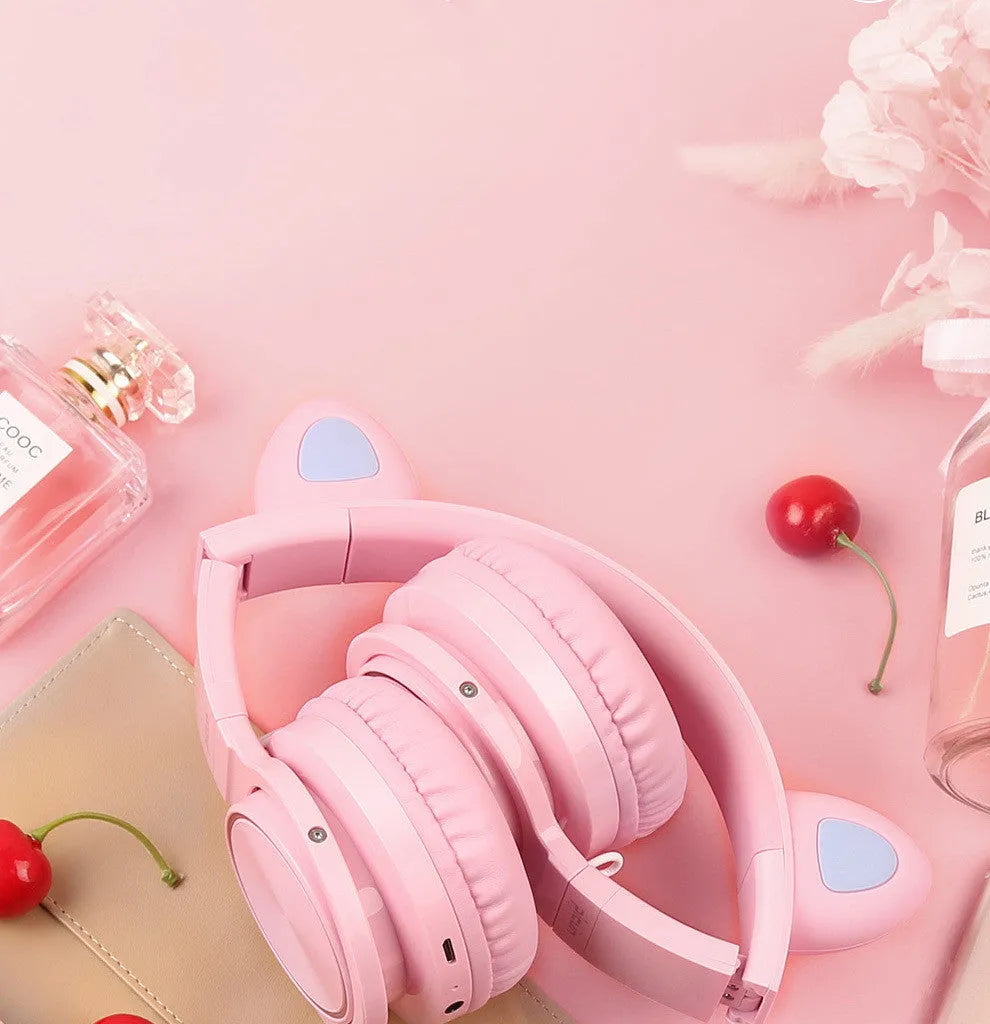 Pink and white Bluetooth over-ear headphones with braided cable and built-in microphone